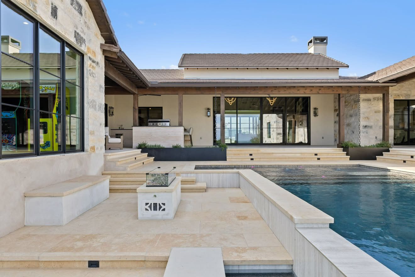 Covered outdoor living area beside a pool